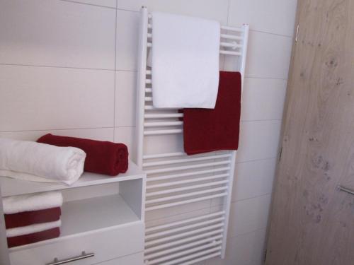 a bathroom with white towels and red towels at Appartements Kroner in Nauders