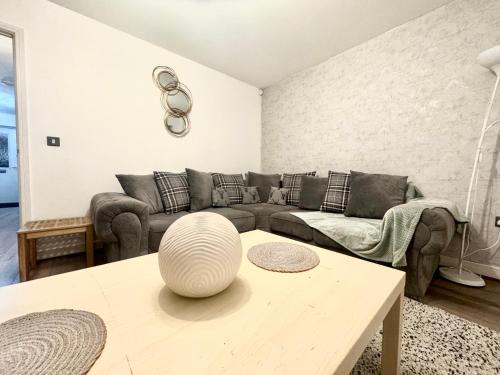 a living room with a couch and a table at Cosy Modern 3-Bed Near Etihad, COOP Arena - AO arena and City Center in Manchester