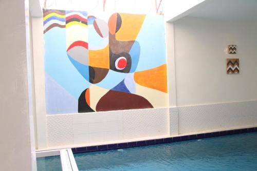 a painting on a wall next to a pool at Villa paradis in Niaga