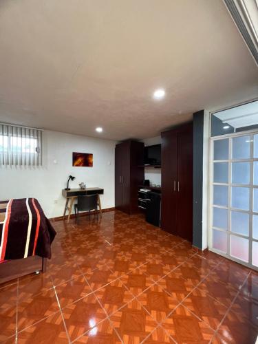 a living room with a wooden floor and a table at Cómoda habitación en Coyoacán in Mexico City