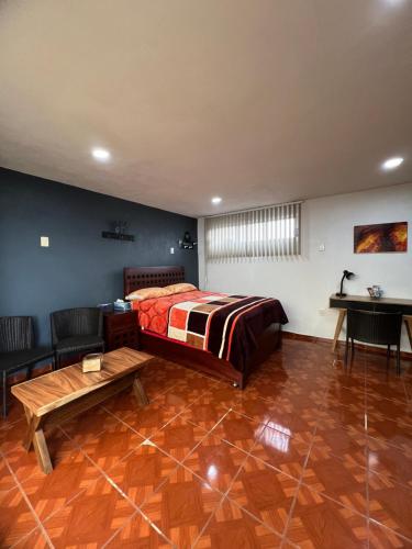 a bedroom with a bed and a table in it at Cómoda habitación en Coyoacán in Mexico City