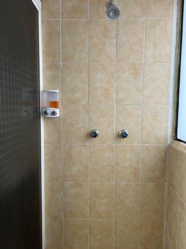 a shower with a glass door and a tile wall at Cómoda habitación en Coyoacán in Mexico City