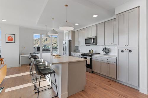 a kitchen with white cabinets and a kitchen island with bar stools at Superb NEW 2BR amazing amenities in Salt Lake City
