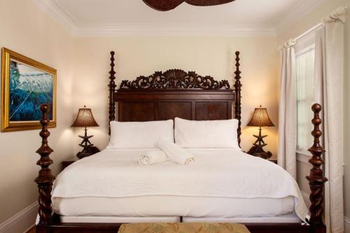 a bedroom with a large bed with a wooden headboard at The Gardens Hotel in Key West