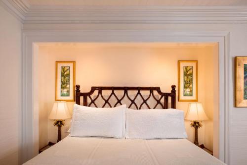 a bedroom with a large bed with two lamps at The Gardens Hotel in Key West