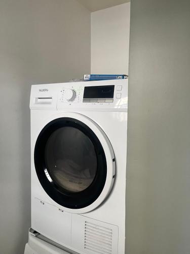 a white washing machine in a corner of a room at Emmanuel INN 1 in Drancy