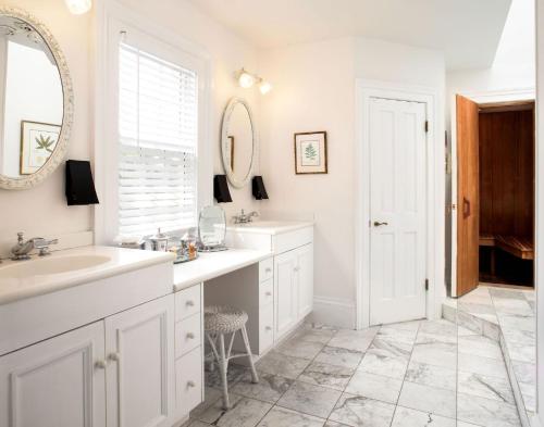 a white bathroom with a sink and a mirror at The Gardens Hotel in Key West