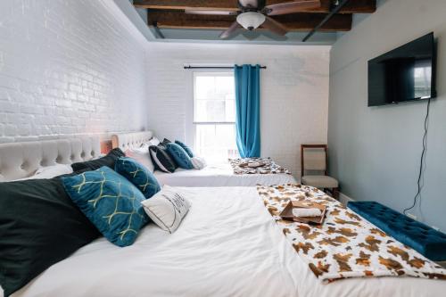 a bedroom with two beds and a flat screen tv at Decatur Sugar Mill Blues in New Orleans