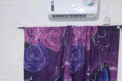 a shower curtain with purple roses on it at Lovely 2 Bedroom House in St Thomas Jamaica in Belfast