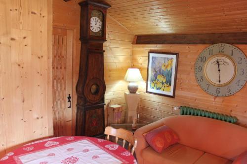 uma sala de estar com um relógio e um sofá em Gîte d'Odile em Le Chambon-sur-Lignon