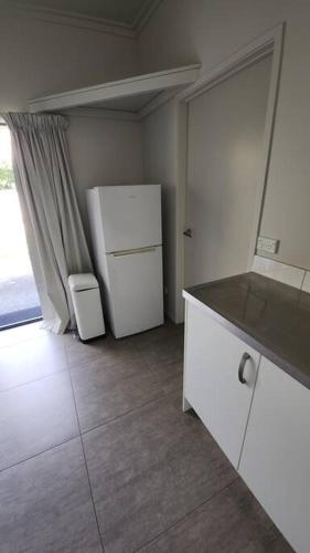 a kitchen with a white refrigerator and a window at Dwelling in Whangarei