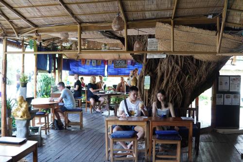チャングーにあるSerenity Eco Guesthouse - CHSE certifiedのレストランのテーブルに座っている人々のグループ