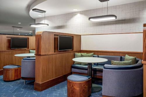 a conference room with tables and chairs and televisions at Courtyard Boston Marlborough in Marlborough