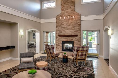 a living room with a fireplace and chairs at Residence Inn by Marriott Chesapeake Greenbrier in Chesapeake