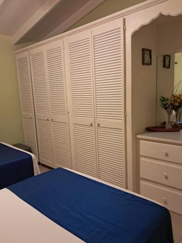 a bedroom with white cabinets and a blue bed at Michand Guest Apartments- Cozy one or two bedroom- 5 walk minutes from airport 10 mins drive to Oistins or beach in Christ Church
