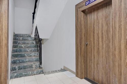 a wooden door in a hallway with a staircase at Hotel O Sai Avenue in Pune