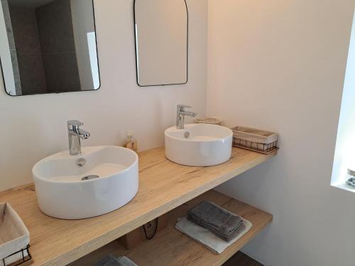 ein Badezimmer mit zwei Waschbecken auf einer Holzplatte in der Unterkunft Stone House in Plouescat near Sandy Beaches in Plounévez-Lochrist