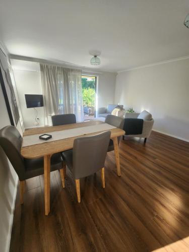 a living room with a wooden table and chairs at Karapiro Apartment in Cambridge