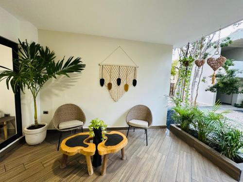 a living room with a table and chairs and plants at Naia Tulum Apartment in Tulum