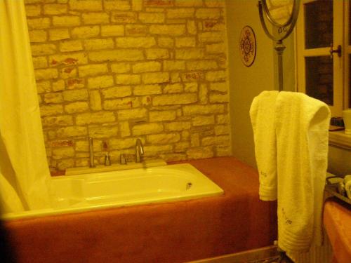 y baño con bañera y pared de ladrillo. en Kedros - Stone house near Vikos canyon, en Ano Pedina