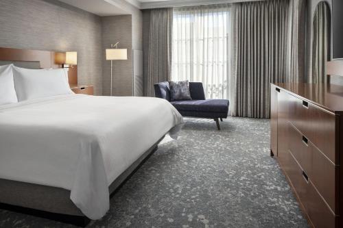 a hotel room with a bed and a chair at The Westin Palo Alto in Palo Alto