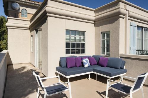 a blue couch on a balcony with two chairs at The Westin Palo Alto in Palo Alto