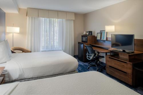 a hotel room with two beds and a desk with a computer at Fairfield by Marriott in Troy