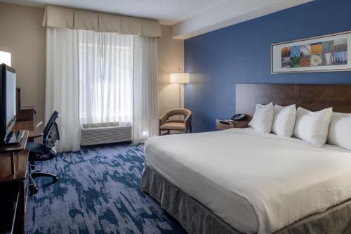 a hotel room with a large bed and a television at Fairfield by Marriott in Troy
