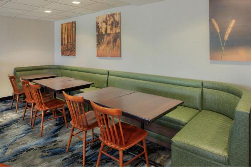 a waiting room with tables and a green couch at Fairfield by Marriott in Troy