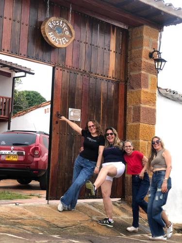 a group of women standing in front of a wooden door at Rustico Hostel Barichara in Barichara