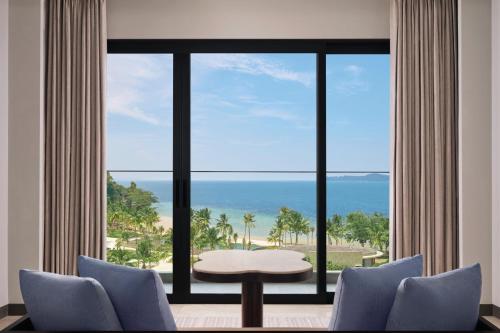 a room with a large window with a view of the ocean at Lampung Marriott Resort & Spa in Lampung
