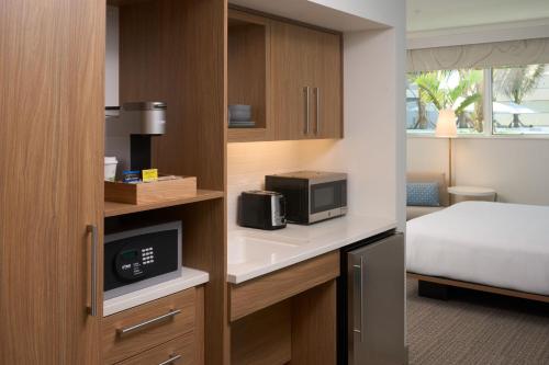 a hotel room with a bed and a microwave at Element Melbourne Oceanfront in Melbourne