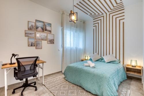 - une chambre avec un bureau et un lit avec une couverture bleue dans l'établissement Chic Marianne - Appt T2 Parking et Terrasse privés, à Montpellier