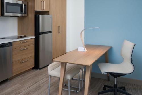 a kitchen with a wooden table and a refrigerator at Element Melbourne Oceanfront in Melbourne