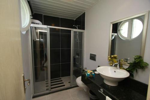 a bathroom with a shower and a toilet and a sink at Nevada Hotel & Spa in Fethiye