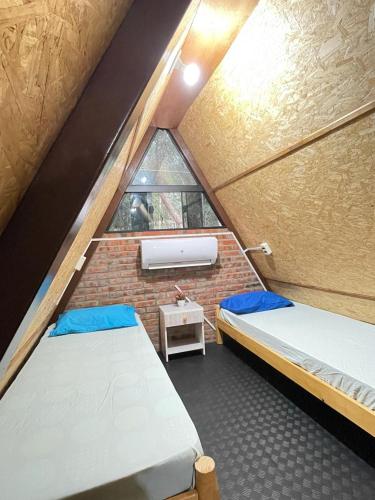 two beds in a small room with a window at Cabaña Tu Lugar Favorito in Santa Elena
