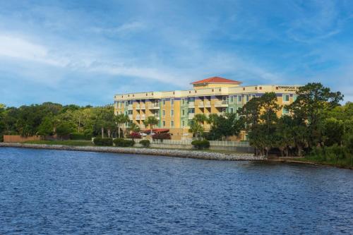 a large yellow building next to a body of water at TownePlace Suites by Marriott Fort Walton Beach-Eglin AFB in Fort Walton Beach