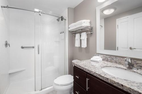 a bathroom with a shower and a toilet and a sink at TownePlace Suites by Marriott Fort Walton Beach-Eglin AFB in Fort Walton Beach