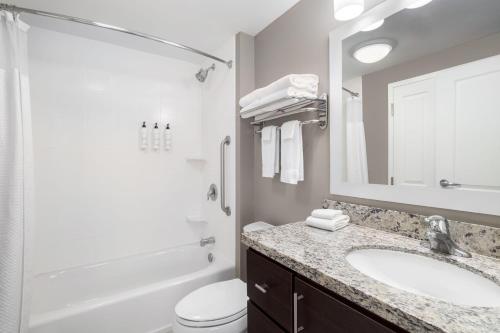 a bathroom with a sink and a toilet and a mirror at TownePlace Suites by Marriott Fort Walton Beach-Eglin AFB in Fort Walton Beach