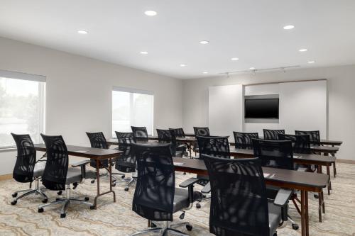 a conference room with tables and chairs and a screen at TownePlace Suites by Marriott Fort Walton Beach-Eglin AFB in Fort Walton Beach