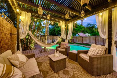 a patio with a hammock and a swimming pool at Chic Boho 3BR Home Near Woodward Park in Fresno