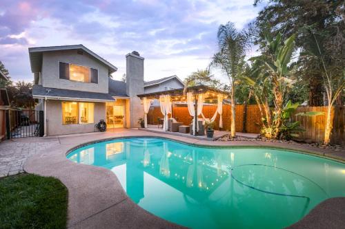a swimming pool in the backyard of a house at Chic Boho 3BR Home Near Woodward Park in Fresno