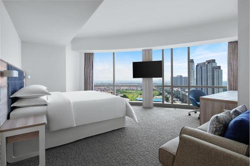 a hotel room with a bed and a large window at Four Points by Sheraton Surabaya, Pakuwon Indah in Surabaya