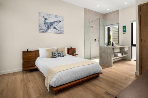 a bedroom with a large bed and a bathroom at Maresia Villa - Luxurious Villa with Infinity Pool, Rooftop and Amazing Views in Providenciales