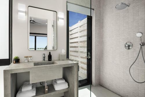 a bathroom with a sink and a shower at Maresia Villa - Luxurious Villa with Infinity Pool, Rooftop and Amazing Views in Providenciales