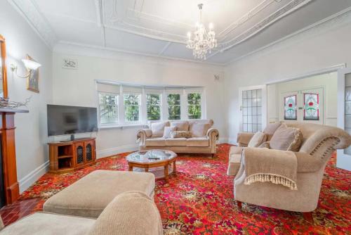 a living room with two couches and a tv at Cambridge House, Bendigo in Bendigo