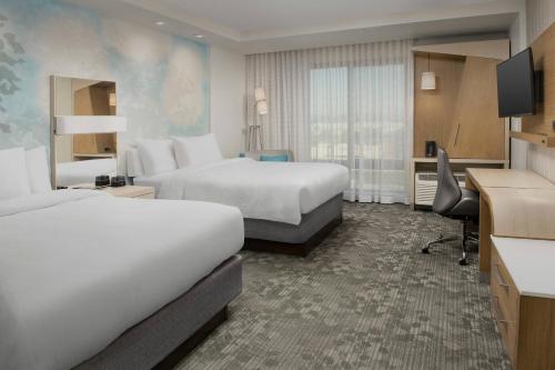 a hotel room with two beds and a desk at Courtyard Portland East in Portland