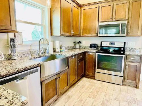 a kitchen with wooden cabinets and stainless steel appliances at The Beach Goat in Gulf Shores