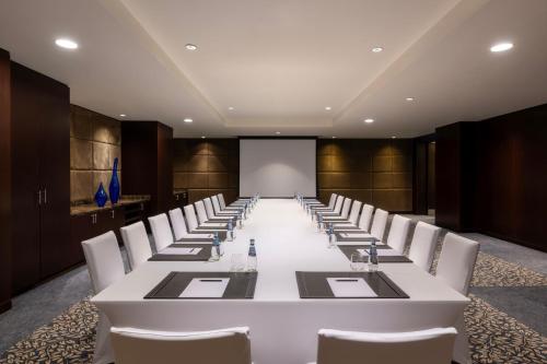 a conference room with a long white table and chairs at JW Marriott Marquis City Center Doha in Doha