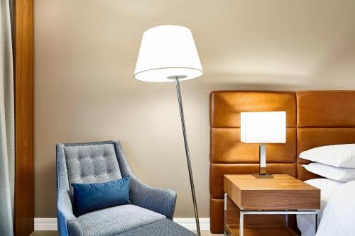 a bedroom with a chair and a lamp and a bed at Sheraton Santos Hotel in Santos